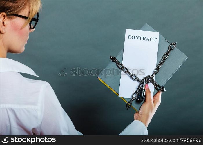 Business concept, limited by contract. Woman holding in hands paper document chained with padlock