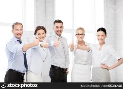 business concept - picture of happy business team showing thumbs up in office