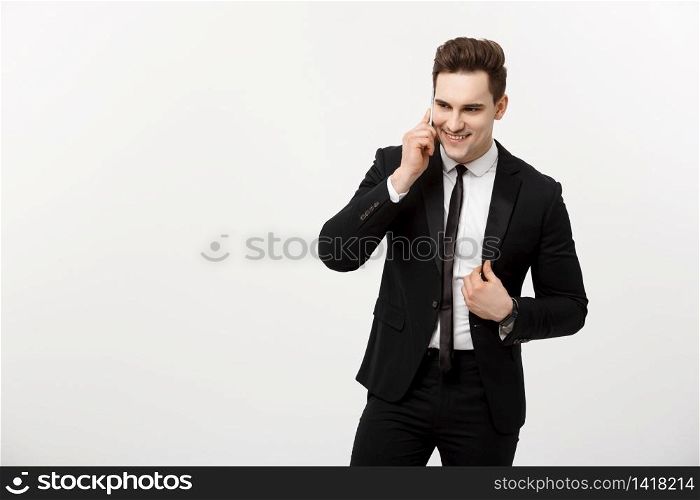 Business Concept: Portrait of a cheerful businessman in smart suit talking on the smart phone isolated on a white background.. Business Concept: Portrait of a cheerful businessman in smart suit talking on the smart phone isolated on a white background