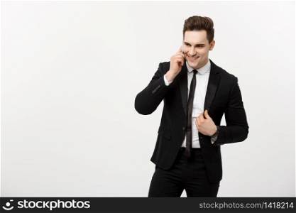 Business Concept: Portrait of a cheerful businessman in smart suit talking on the smart phone isolated on a white background.. Business Concept: Portrait of a cheerful businessman in smart suit talking on the smart phone isolated on a white background
