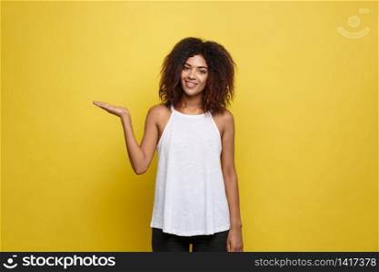 Business Concept - Portrait of beautiful calm young african american presenting by pointing hand on side. Business Concept - Portrait of beautiful calm young african american presenting by pointing hand on side.