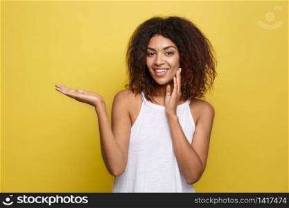 Business Concept - Portrait of beautiful calm young african american presenting by pointing hand on side. Business Concept - Portrait of beautiful calm young african american presenting by pointing hand on side.