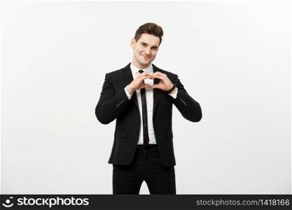 Business Concept: Portrait of charming attractive businessman holding hands in heart gesture and lifting eyebrows while smiling, isolated over white grey background. Business Concept: Portrait of charming attractive businessman holding hands in heart gesture and lifting eyebrows while smiling, isolated over white grey background.