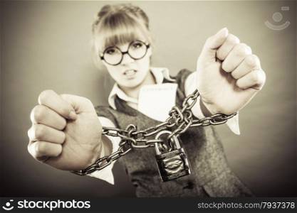 Business concept. Serious businesswoman with chained hands holding contract