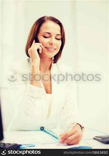 business concept - smiling businesswoman with smartphone in office