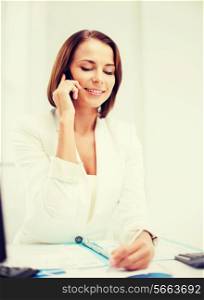 business concept - smiling businesswoman with smartphone in office