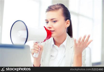 business concept - strict businesswoman shouting in megaphone in office. strict businesswoman shouting in megaphone