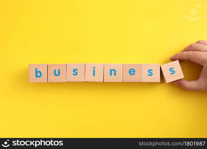 Business concept wooden blocks with word business strategy icons on yellow background