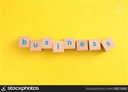 Business concept wooden blocks with word business strategy icons on yellow background