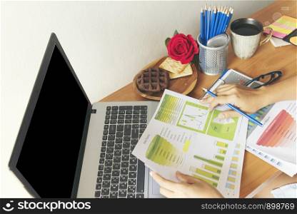 business concept. young beautiful woman using laptop and reading document report at her table.