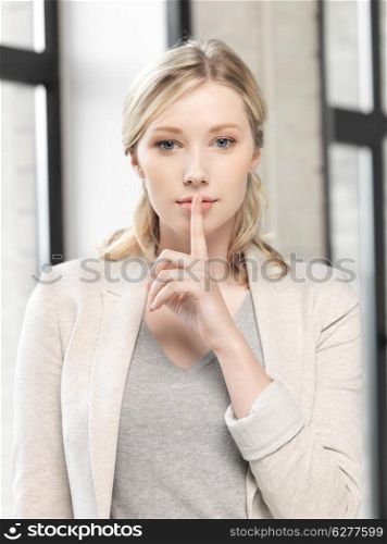 business concept - young woman with finger on lips