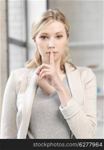 business concept - young woman with finger on lips