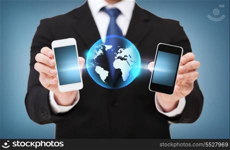 business, connectivity, internet and technology concept - businessman showing two smartphones with globe