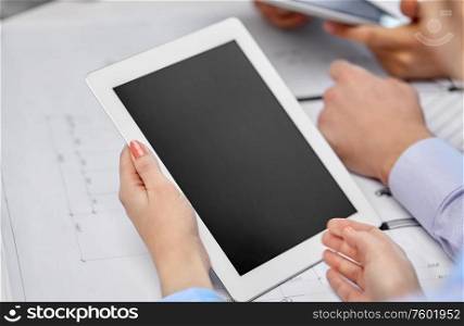 business, construction and people concept - group of architects with tablet pc computer and blueprint at office. architects with tablet pc and blueprint at office