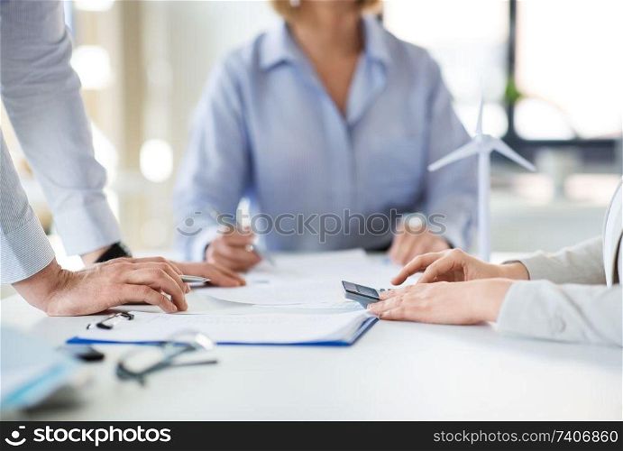business, corporate and people concept - colleagues with papers and calculator at office. business team with papers and calculator at office
