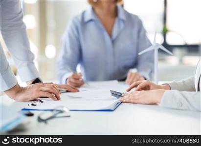 business, corporate and people concept - colleagues with papers and calculator at office. business team with papers and calculator at office