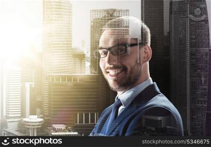 business, corporate and people concept - smiling businessman in glasses over city buildings background and double exposure effect. smiling businessman in glasses over city buildings