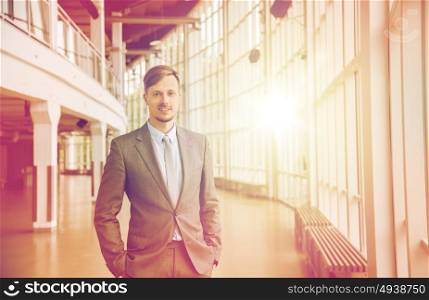 business, corporate and people concept - young businessman in suit at office building hall. young businessman in suit at office building hall