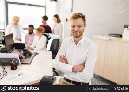 business, corporate, people and teamwork concept - happy young man over creative team in office