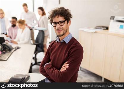 business, corporate, people and teamwork concept - happy young man over creative team in office. happy young man over creative team in office