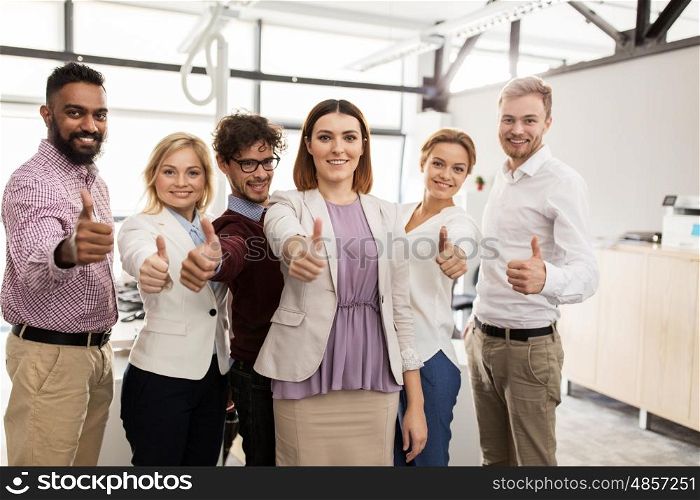 business, corporate, people, gesture and teamwork concept - happy smiling creative team showing thumbs up at office