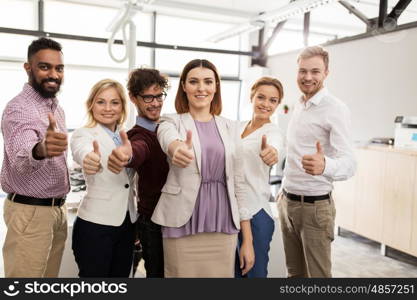 business, corporate, people, gesture and teamwork concept - happy smiling creative team showing thumbs up at office