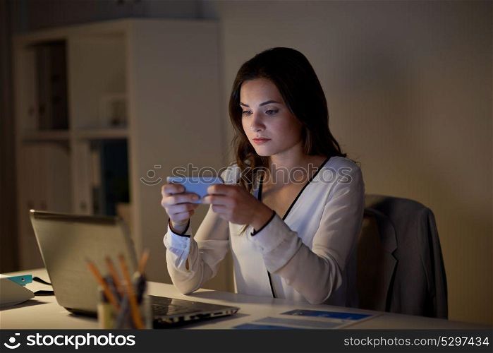 business, corporate, technology and people concept - businesswoman with smartphone and laptop at office. businesswoman with smartphone and laptop at office