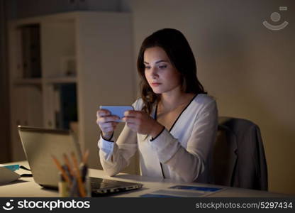 business, corporate, technology and people concept - businesswoman with smartphone and laptop at office. businesswoman with smartphone and laptop at office