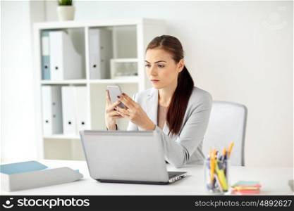 business, corporate, technology and people concept - businesswoman with smartphone at office