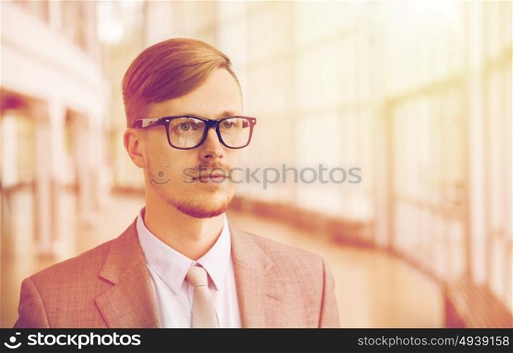 business, corporate, vision and people concept - young businessman in suit and glasses at office. young businessman in suit and glasses at office