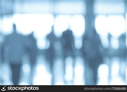 Business corporation abstract background - blurred corridor in a corporate office or airport with people in motion (blue filter effect)
