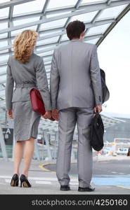 Business couple arriving at airport