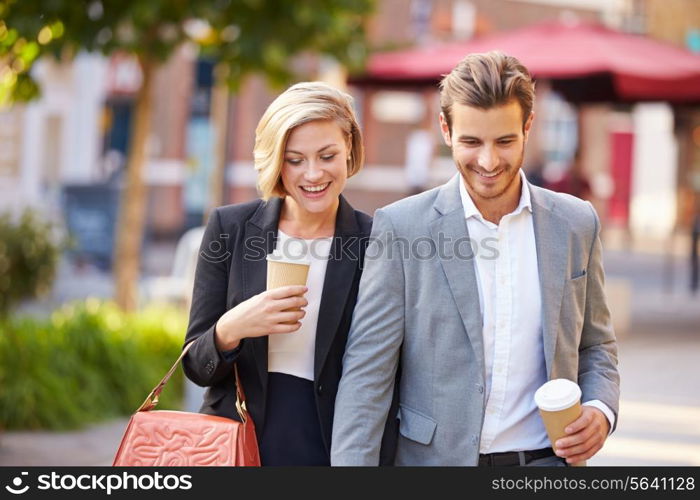 Business Couple Walking Through Park With Takeaway Coffee