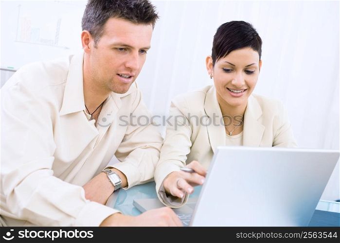 Business couple working at office, smiling.
