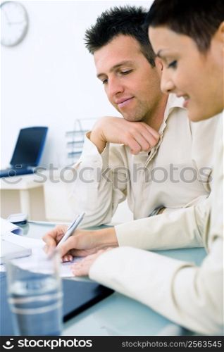 Business couple working at office, smiling.
