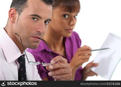 Business couple writing in a pad