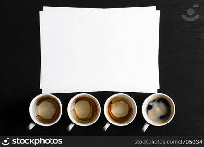 business creativity concept. empty and full cups of fresh espresso with blank paper on desk