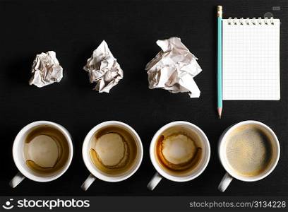 business creativity concept. empty and full cups of fresh espresso with crumple wads on desk