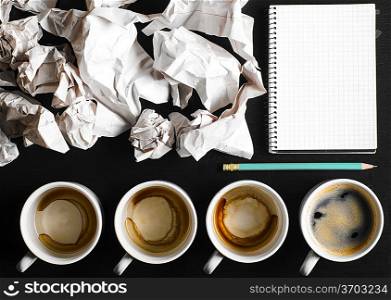business creativity concept. empty and full cups of fresh espresso with crumple wads on desk