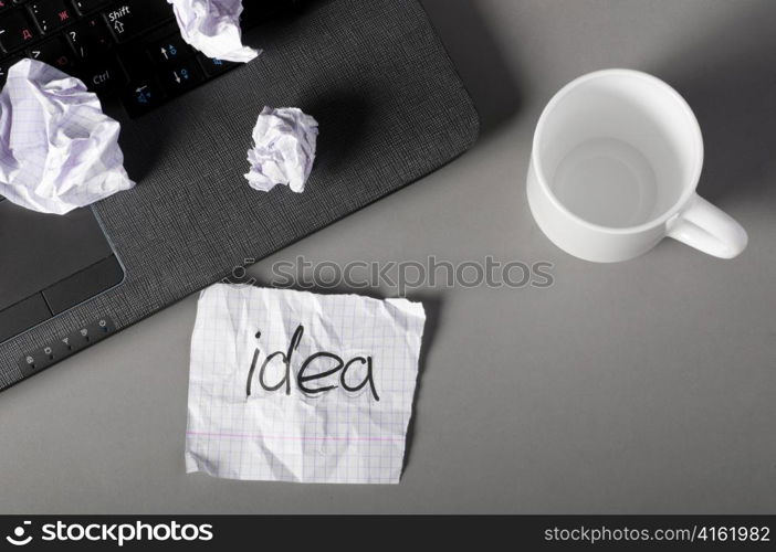 business creativity concept. Laptop, sheets of paper and crumpled wads on table.