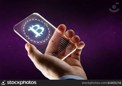 business, cryptocurrency and future technology concept - close up of businessman hand with charts on transparent smartphone and bitcoin hologram over ultra violet space background. hand with smartphone and bitcoin hologram