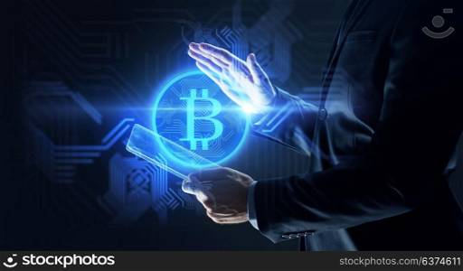 business, cryptocurrency and future technology concept - close up of businessman with transparent tablet pc computer and virtual bitcoin symbol hologram over black background. businessman with tablet pc and bitcoin hologram