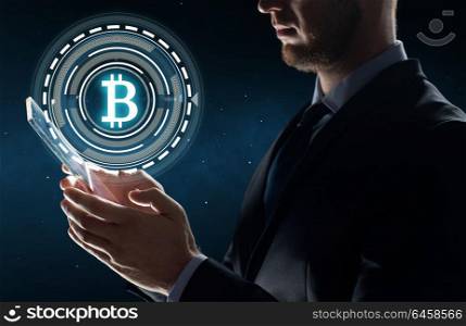 business, cryptocurrency and future technology concept - close up of businessman with transparent tablet pc computer and virtual bitcoin symbol hologram over space background. businessman with tablet pc and bitcoin hologram