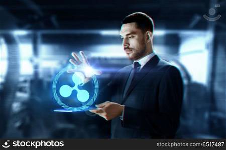 business, cryptocurrency and future technology concept - close up of businessman with transparent tablet pc computer and virtual ripple symbol hologram over abstract background. businessman with tablet pc and ripple hologram. businessman with tablet pc and ripple hologram