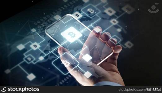 business, cryptocurrency and future technology concept - close up of hand with virtual bitcoin block chain hologram transparent smartphone screen over black background. close up of hand with smartphone and bitcoin