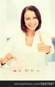 business, currency, banking and finances concept - picture of lovely woman with piggy bank and cash money showing thumbs up