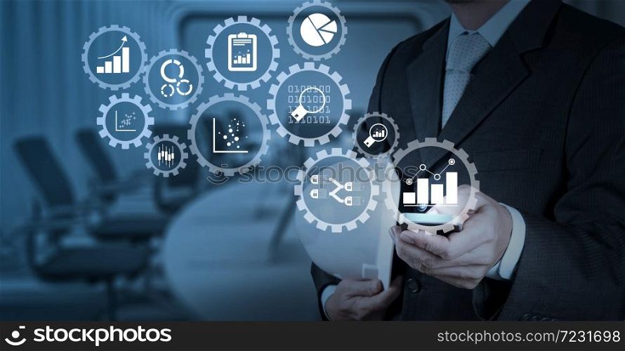 Business data analytics management with connected gear cogs with KPI financial charts and graph.Businessman hand working with a digital tablet on meeting room background