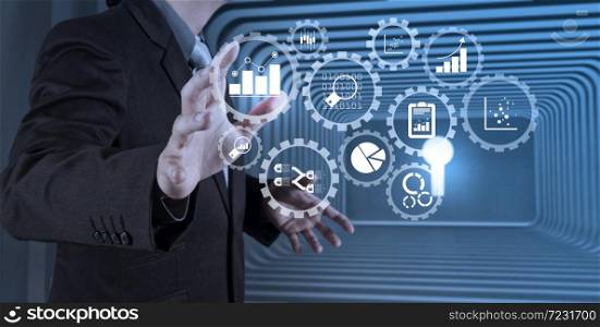 Business data analytics management with connected gear cogs with KPI financial charts and graph.business man with an open hand as showing something concept