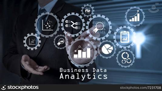 Business data analytics management with connected gear cogs with KPI financial charts and graph.businessman hand working with touch screen in action
