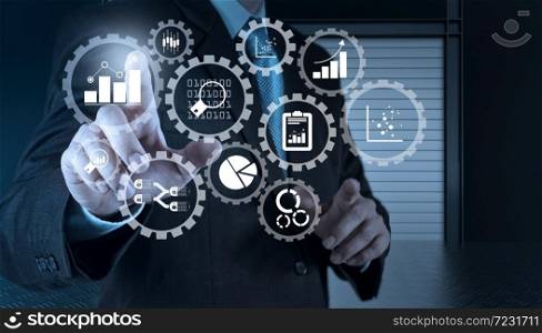 Business data analytics management with connected gear cogs with KPI financial charts and graph.businessman hand working with touch screen in action
